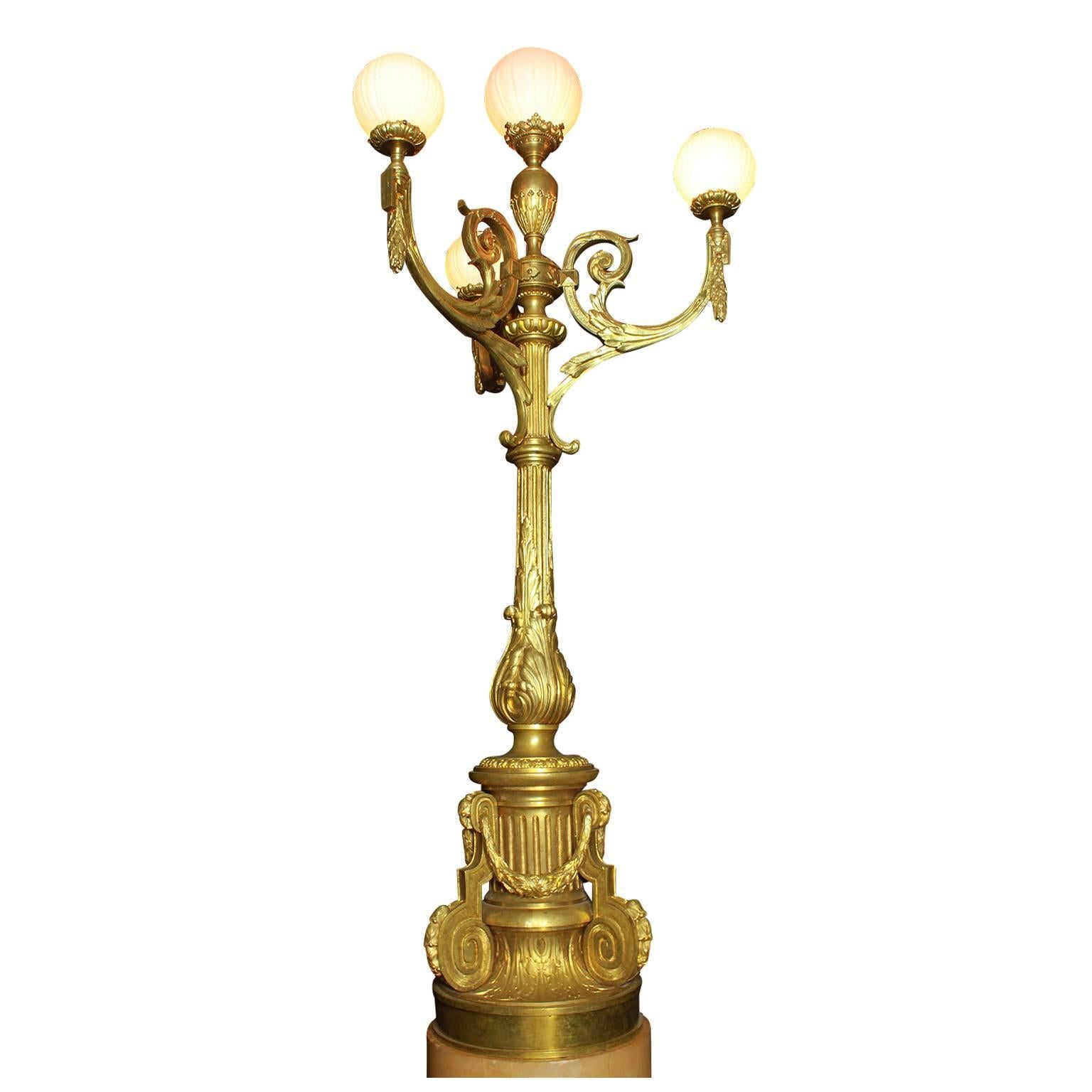 Eine schöne und große französische Fackel aus vergoldeter Bronze im Stil der Belle Époque des 19. und 20. Jahrhunderts mit Lorbeerkränzen und weißen Opalglaskugeln, auf einem zweifarbigen, runden Marmorsockel, um 1900, Paris.

Gesamthöhe: 99 1/2