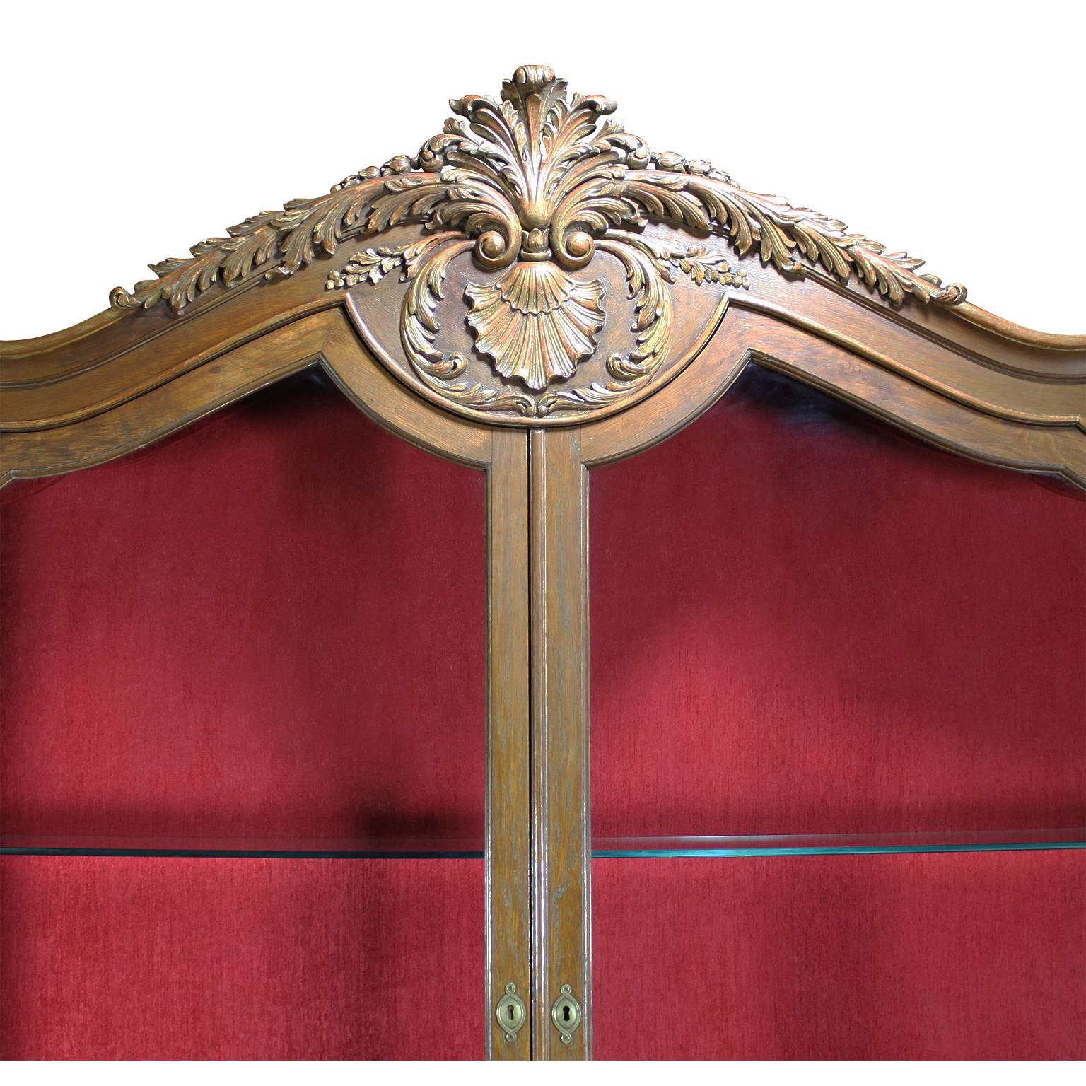 Fina y rara consola vitrina inglesa de estilo Chippendale del siglo XIX-XX, tallada en roble y dorada. La estrecha vitrina superior de dos puertas está coronada por una pluma de pavo real tallada y dorada, rematada con follaje sobre una concha