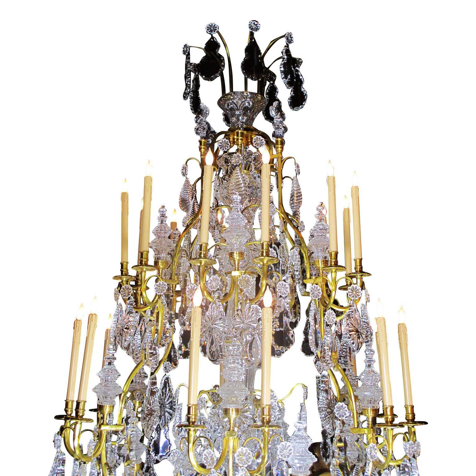 A very large fine and palatial 20th century Louis XV style gilt bronze and cut-glass twenty-four-light chandelier (There are two of these chandeliers available), the solid bronze frame with towers and Fleur de lis and a central support, in the