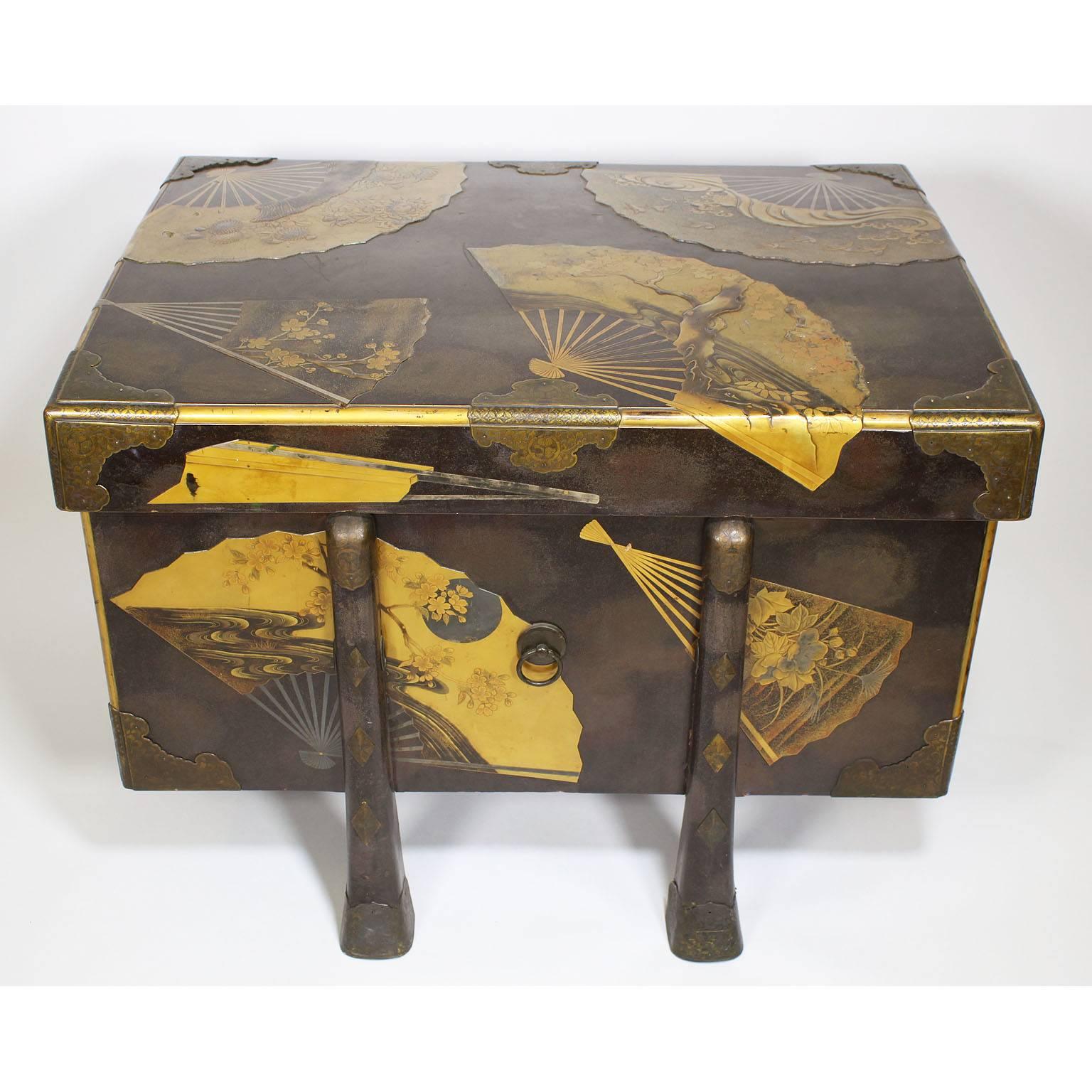 A very fine Japanese Meiji period lacquered karabitsu trunk of square form and raised on six tapering legs. The traveling box is decorated in gold Hiramakie and Nashiji on Roiro ground, with decorations of fans engraved and gilt Kanagu, circa