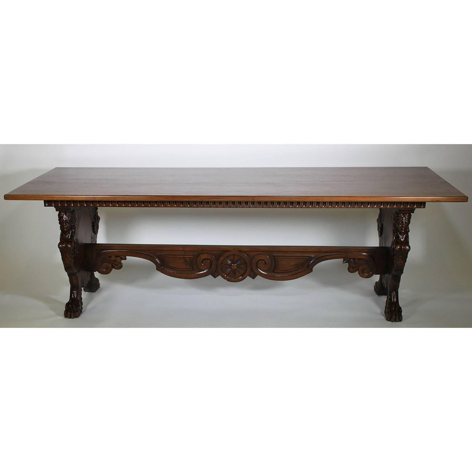 A fine and Large Italian 19th-20th century Baroque style carved walnut tavern table or dining table. The long rectangular top (later) atop a pair of carved bases with figures of winged maiden, shells, scrolls and centred with a roaring lion head.