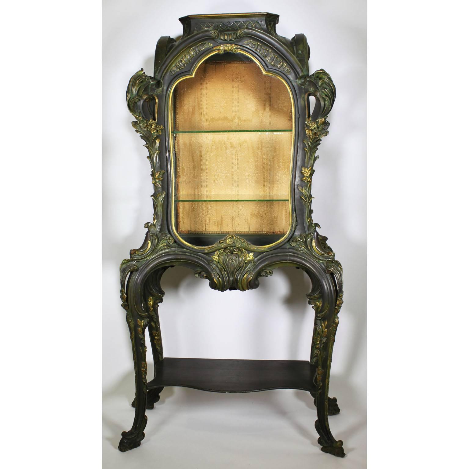 A whimsical rare French 19th-20th century whimsical Art Nouveau green and parcel giltwood carved single door vitrine cabinet. The highly stylized body with a front glass door and two side glass panels all flowing with curvilinear forms of organic,