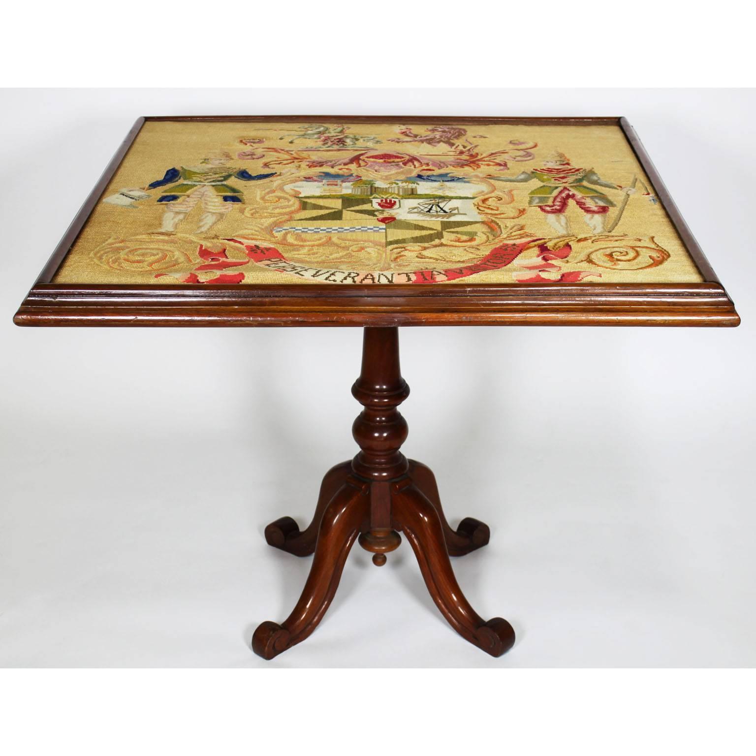 An English late 19th century mahogany and needlepoint Victorian tilt-top game table. The square top mounted with a figural needlepoint coat-of-arms "Perseverantia Victor", London, circa 1890.

Measures: Height (Tilted) 48 1/4 inches