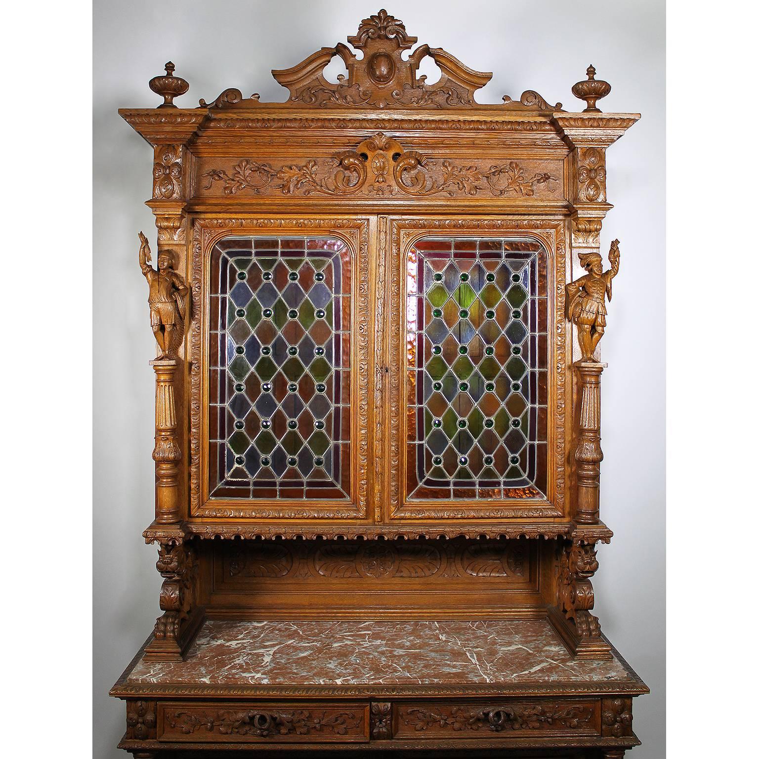 A fine and rare Italian 19th century Baroque style oak-carved figural credenza cabinet. The upper part with a pair of colorful Vitreaux (Stained glass) panelled doors, surmounted on each side with a figure of a young fisherman holding a net and a