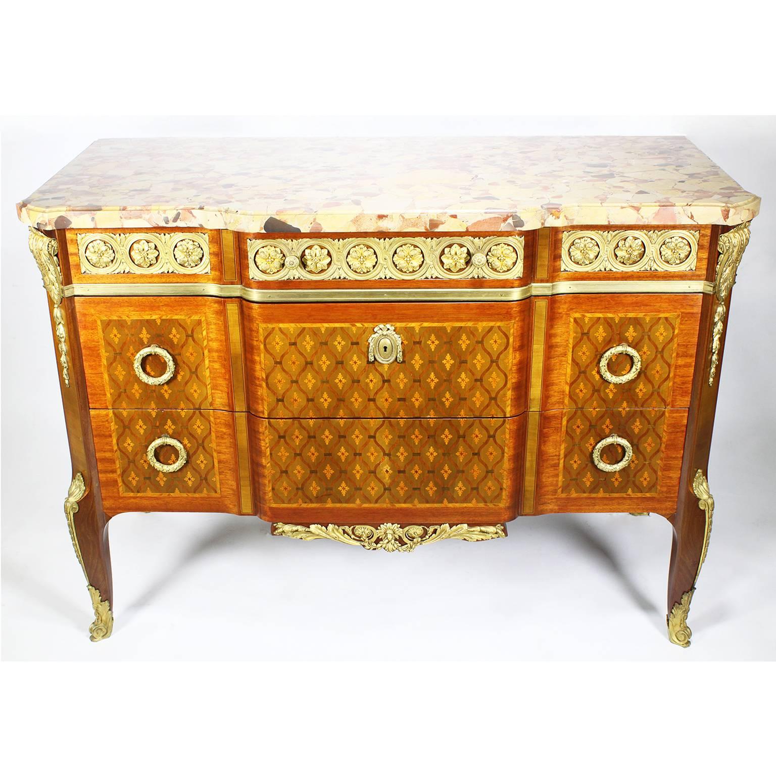 Una raffinata commode francese del XIX secolo in stile Regence, finemente cesellata e montata in ormolu, con intarsio e parquet in tulipano e satinwood e piano in marmo brêche d'alep. Il fronte a serpentina con tre grandi cassetti con tiretti ad