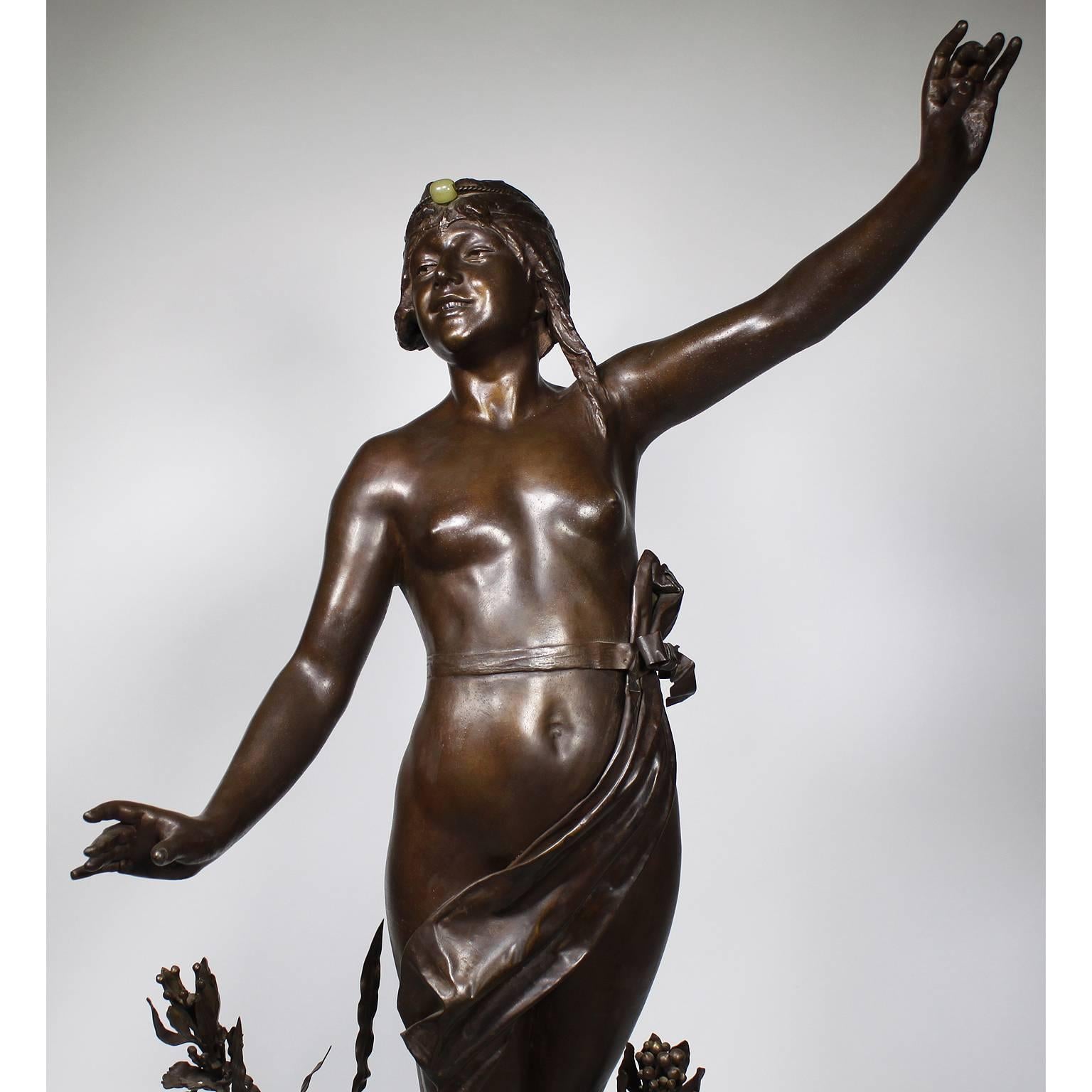 Imposante et fine figure en petit bronze Art-Déco représentant une jeune fille orientale semi-nue debout, en patine brune, attribuée à Louis Hottot (français, 1834-1905). La jeune beauté souriante, seins nus, pose les bras tendus, les cheveux