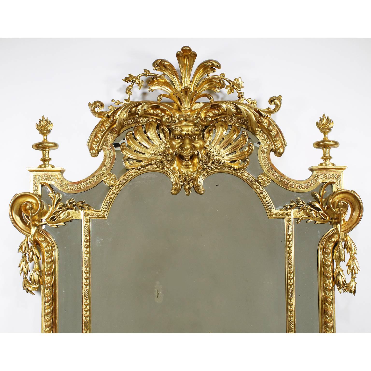 Très beau cadre de miroir figuratif en bois doré et gesso sculpté de style Empire français du XIXe siècle, flanqué d'une paire de sphinx ailés assis, avec des rinceaux sculptés, des guirlandes et couronné d'un masque de satyre sculpté et percé avec