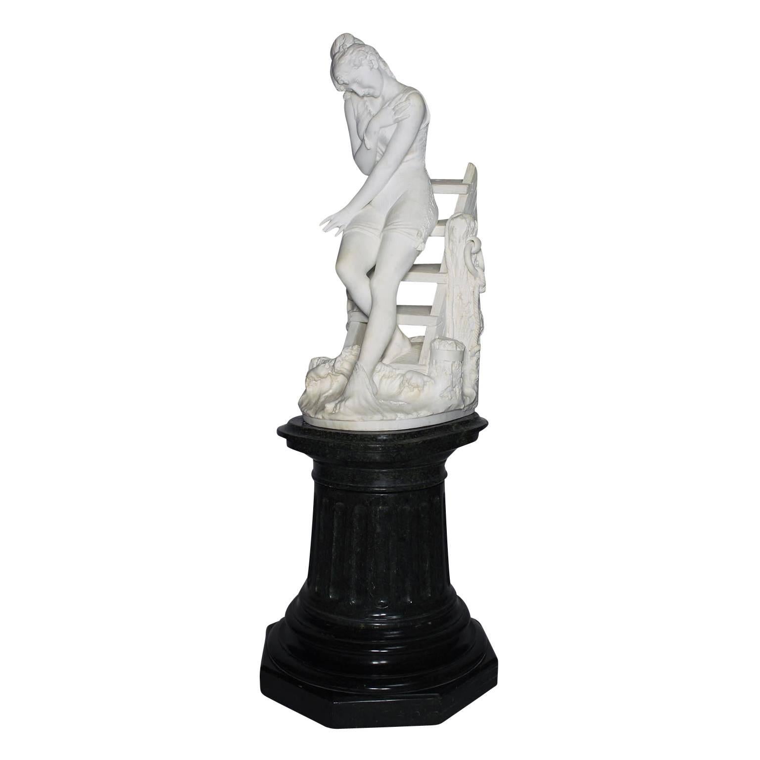 An very fine Italian 19th century Carrara marble sculpture depicting a young beauty going for a Swim standing on the steps of a dock, raised on its original carved green marble pedestal, by Emilio Fiaschi (Italian, 1858-1941). The intricately carved