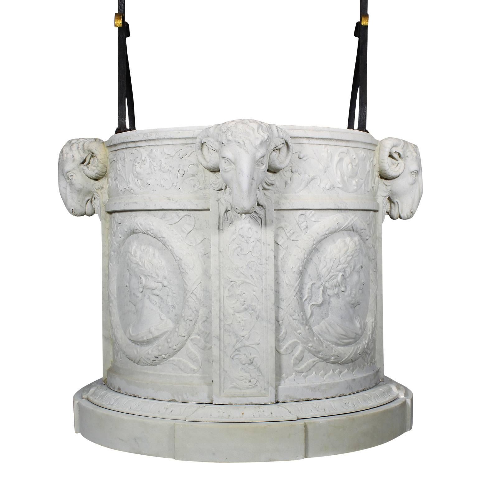 A fine Italian 19th century carved Carrara marble and wrought iron wishing well head (It may also be used as a planter). The white marble cylinder surmounted with a parcel-gilt wrought iron and toleware arched frame decorated with flower heads, the