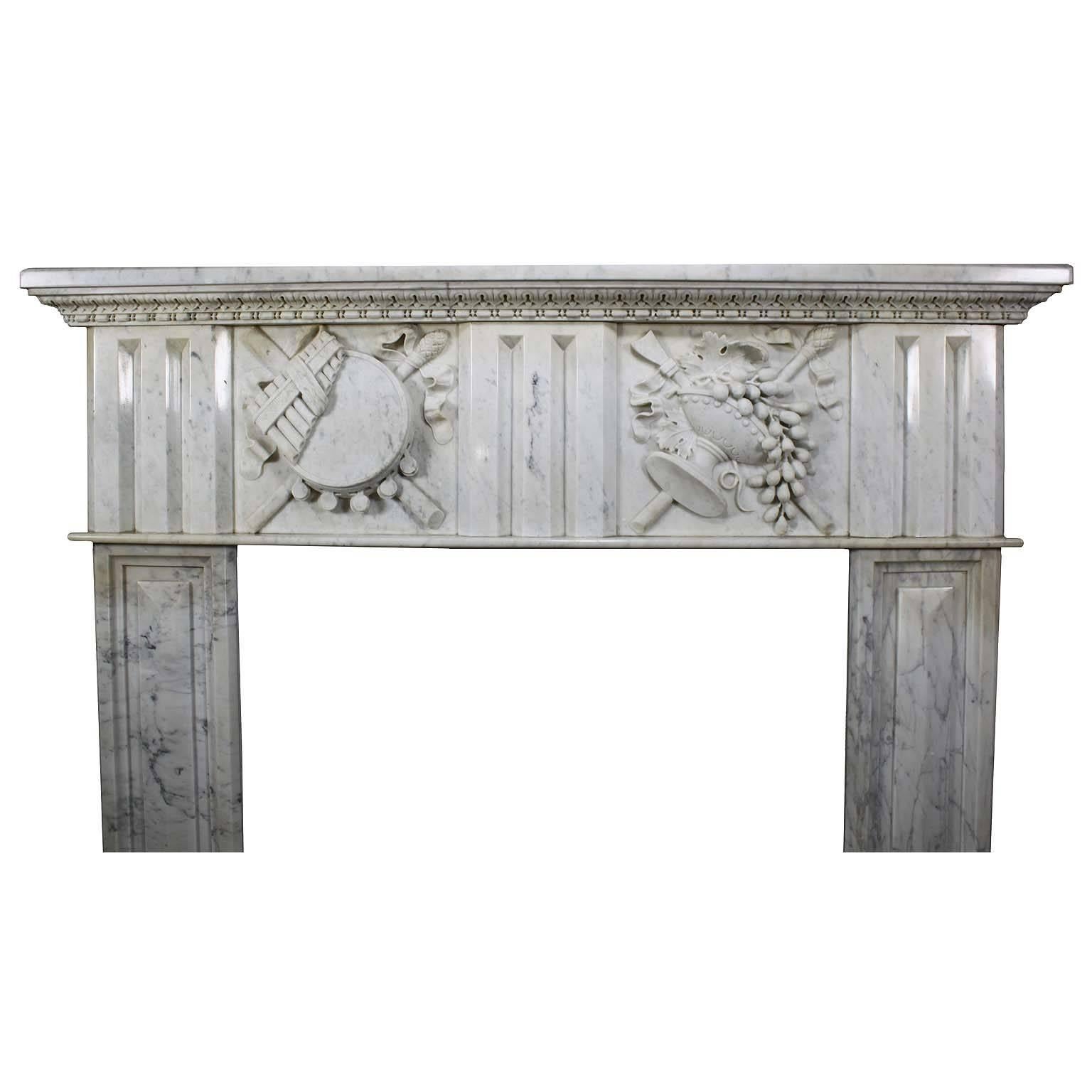 Fine French 19th century Louis XVI style carved white marble fireplace mantel surround. The apron with carvings of musical instruments and allegorical to abundance with fruits and ribbons within an urn, Paris, circa 1880.

Measures: Height 53 3/4