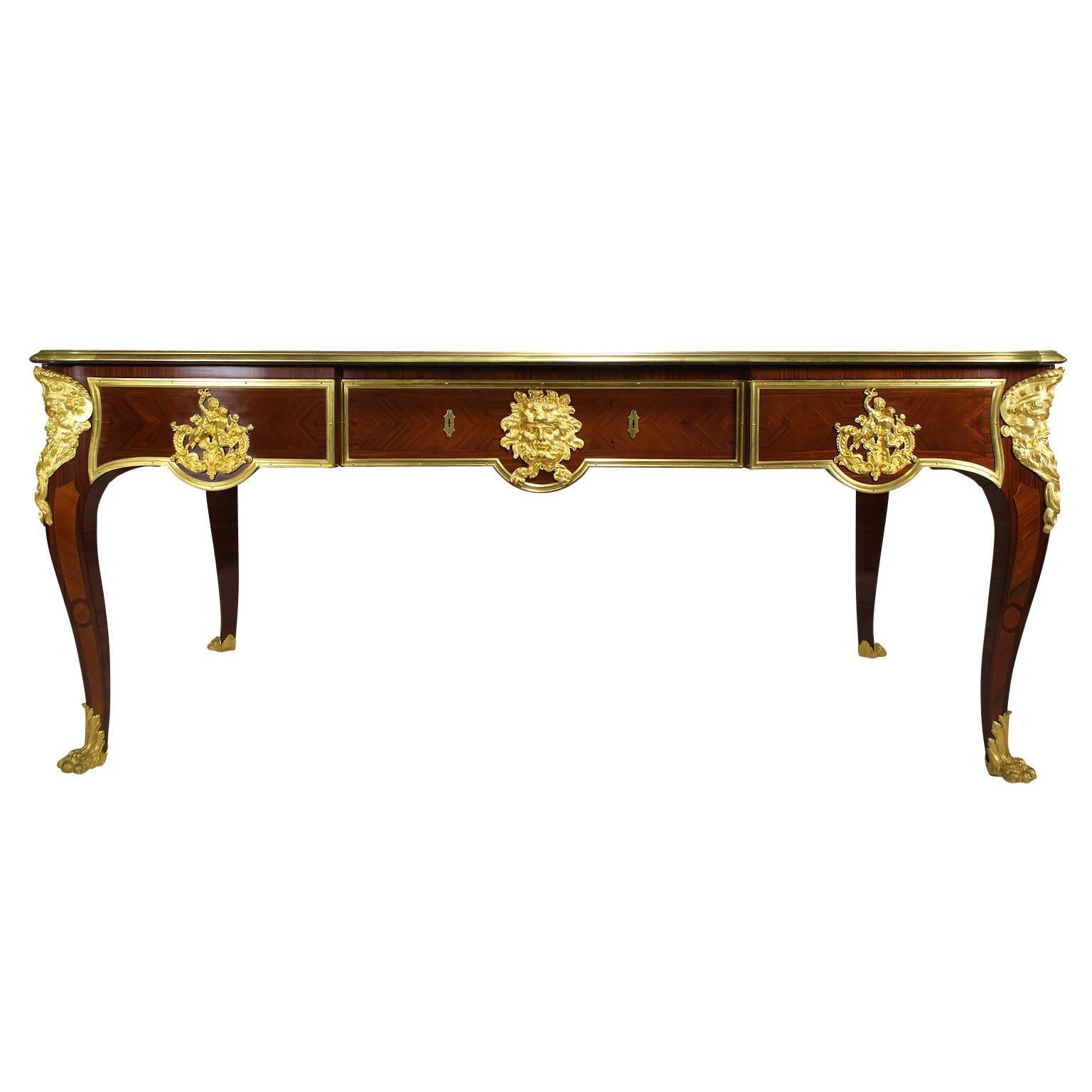 A very fine and large French 19th century Louis XV style ormolu-mounted mahogany and kingwood three-drawer bureau plat attributed to Paul Sormani (French-Italian 1817-1877). The shaped rectangular top enclosing a gilt tooled brown leather writing