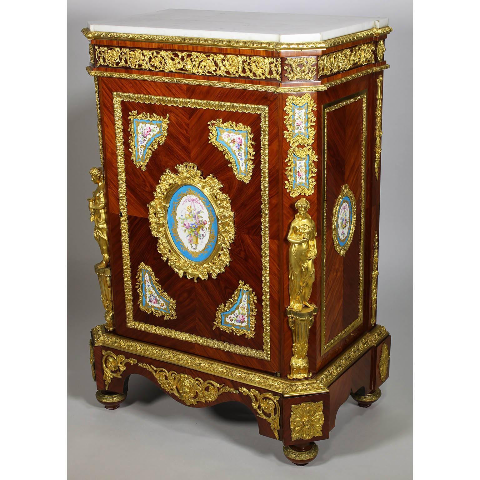 A very fine pair of French Napoleon III figural ormolu and porcelain (probably Sevres) mounted tulipwood Meuble A Hauteur D'Appui. The rectangular shaped body fitted with a white marble top on canted corners. The reticulated frieze of scrolling