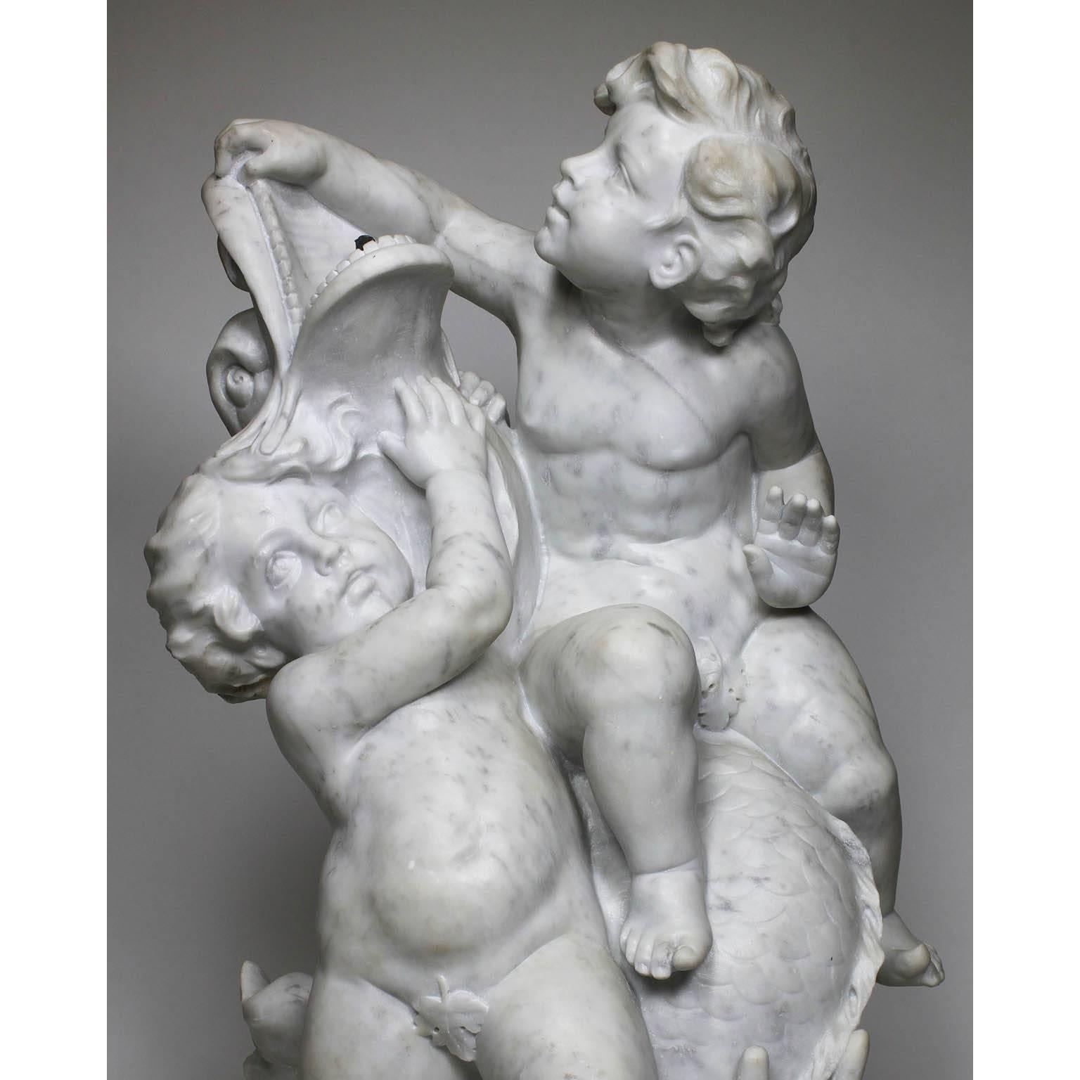 A fine and charming French 19th-20th century carved white marble whimsical group sculpture depicting two putti (Children) playing with a dolphin, fitted for use as a fountain, Paris, circa 1900.

Measures: Height 36 1/4 inches (92.1 cm)
width 21 1/4