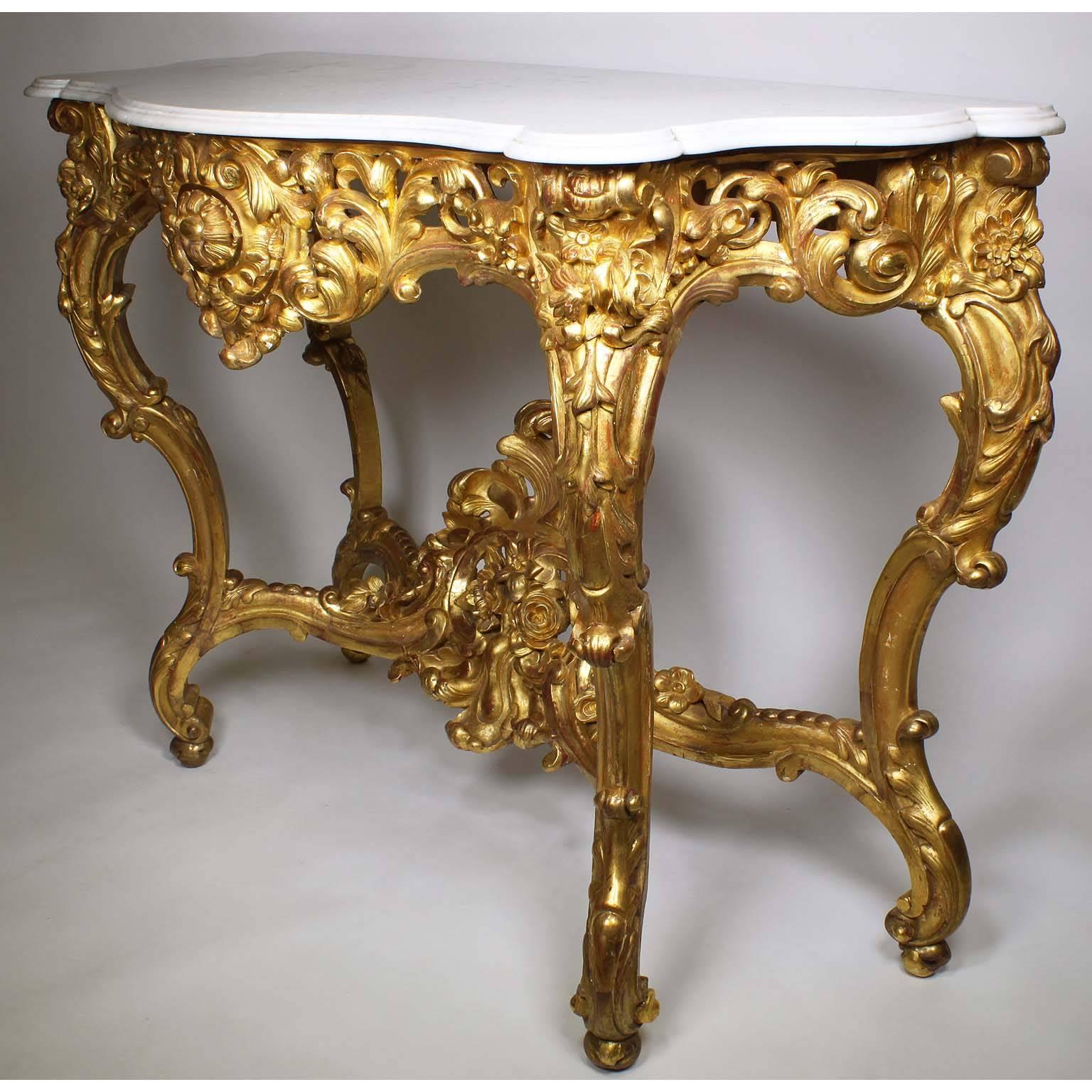 A fine French Belle Époque 19th-20th century, Louis XV style giltwood carved wall console table with marble top. The front intricately carved apron with scrolls and acanthus within floral design. The four cabriolet 