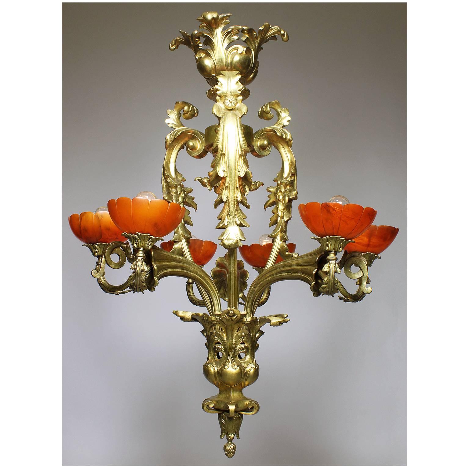 Ein feiner und seltener französischer Belle Époque-Kronleuchter des frühen 20. Jahrhunderts mit sechs Lichtern aus vergoldeter Bronze und rubinroten, geschnitzten Alabasterschirmen. Rahmen aus vergoldeter Bronze in Form eines Blumenbouquets mit drei