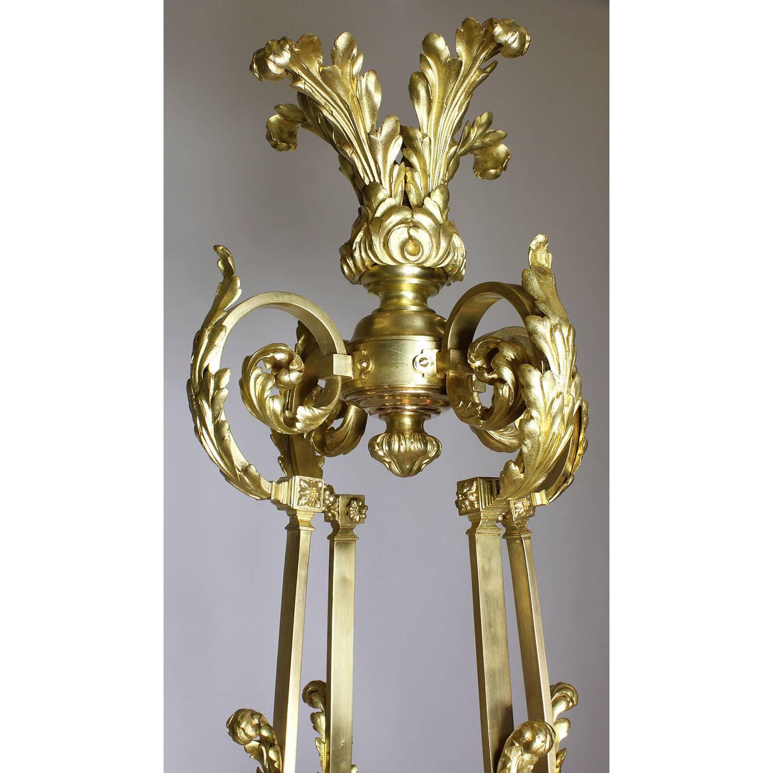 A Fine and large French 19th-20th century Neoclassical Revival style gilt bronze five-light chandelier. The elongated gilt bronze frame in the form of an ancient Empire hanging oil burning lamp suspended by four shackle supports surmounted with