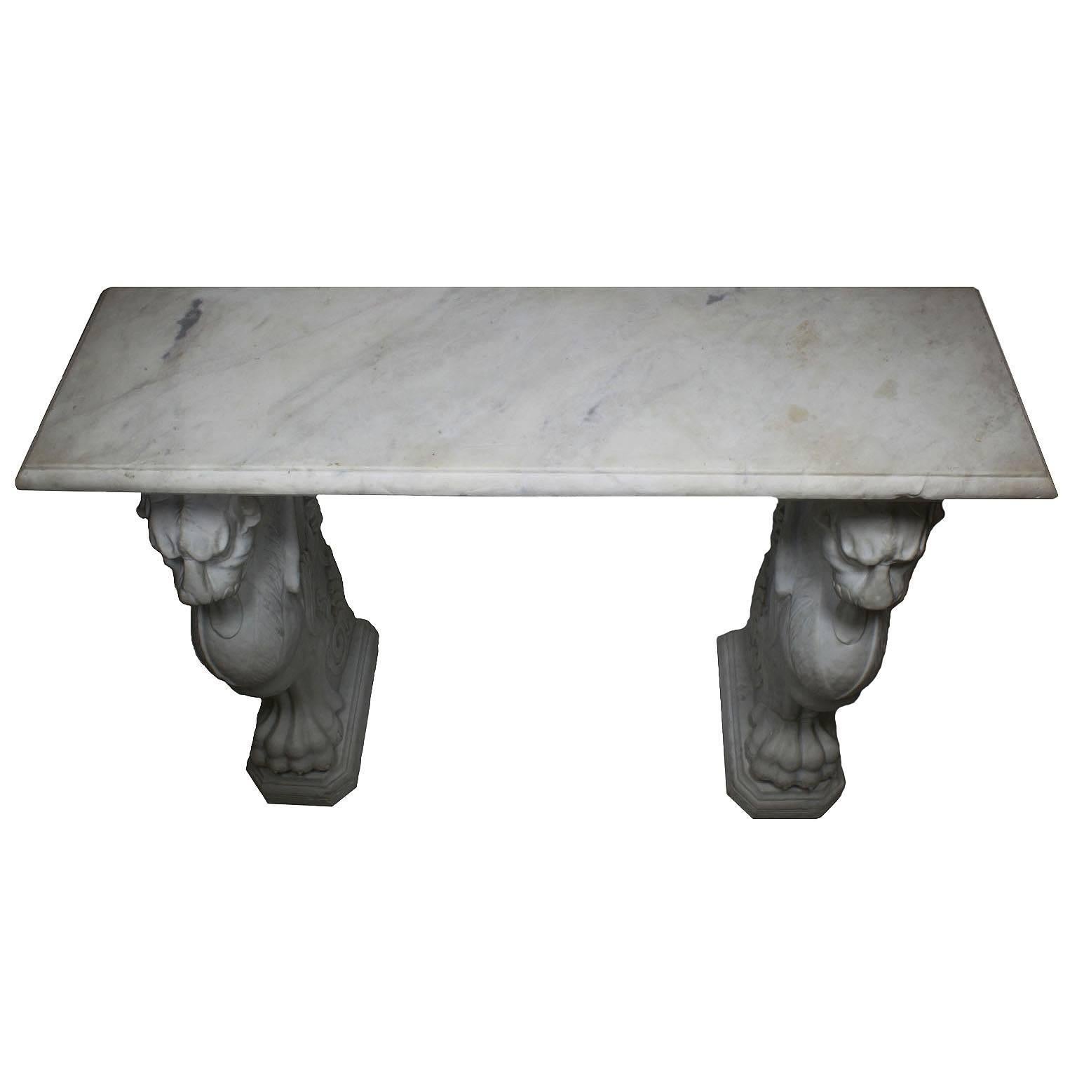 A Large Italian 19th century neoclassical Revival style carved Carrara marble figural wall console table. The rectangular marble top supported by twin Roman carved marble monopodiums of winged chimaera lions forepart on lion legs with paw feet. This