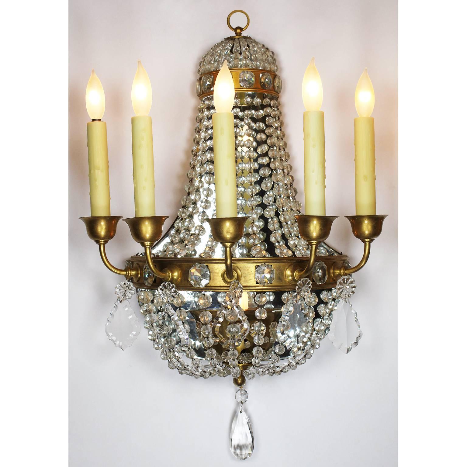 A fine pair of French neoclassical Revival Louis XVI style gilt bronze and cut-glass six-light wall sconces. The semi-circular gilt bronze frame surmounted with five candle-light cups, strands of diamond shaped cut-glass in the shape of a basket and