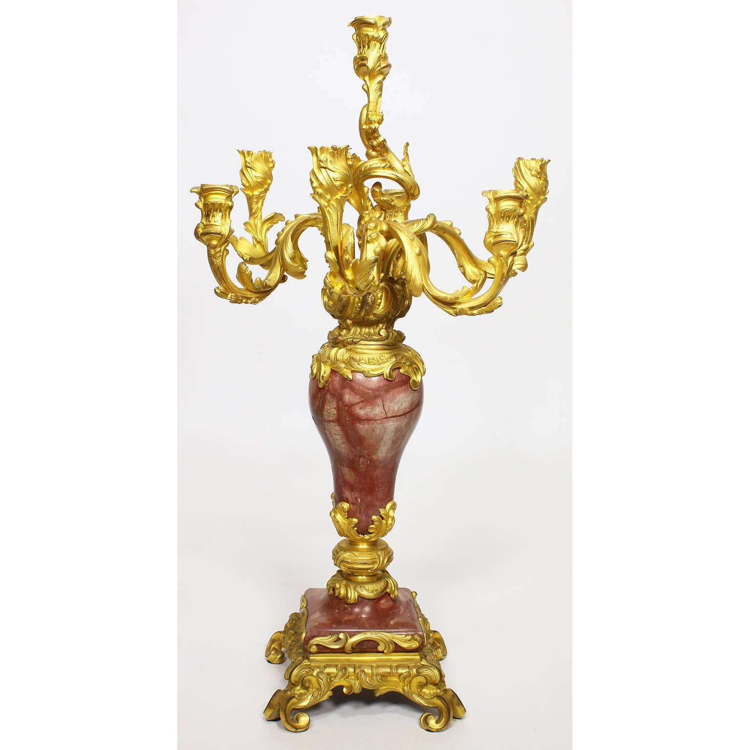 A very fine pair of French 19th century Louis XV style gilt-bronze and rouge royal marble seven-light candelabra. The ornate gilt-bronze candelabrum with six scrolled candle-arms and a single middle candle-holder, surmounted with flowers, all