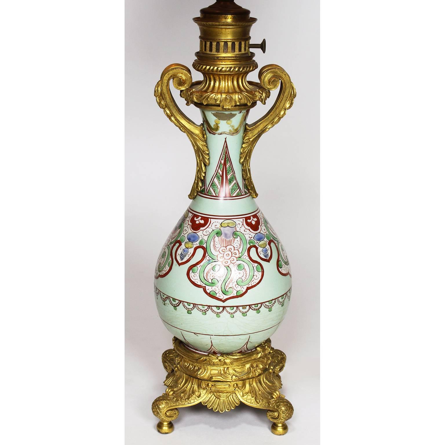 A fine pair of Chinese Export, 19th century porcelain bottle vases mounted with French ormolu as oil lamps. The well potted ovoid porcelain pear-shaped body decorated with hand-painted asymmetrical and floral designs in pale-green, red, light-blue