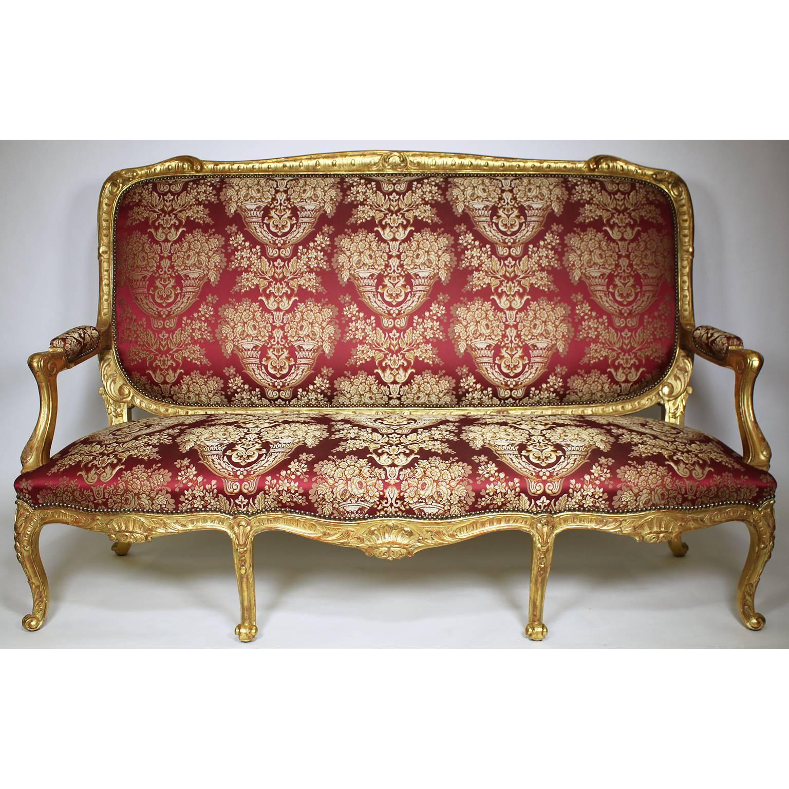 Très bel ensemble de salon palatial français du XIXe siècle de style Louis XV en bois doré sculpté, comprenant un canapé et quatre fauteuils à la reine, tous de grande taille, à haut dossier et récemment retapissés, Paris, vers 1880.

Mesures :