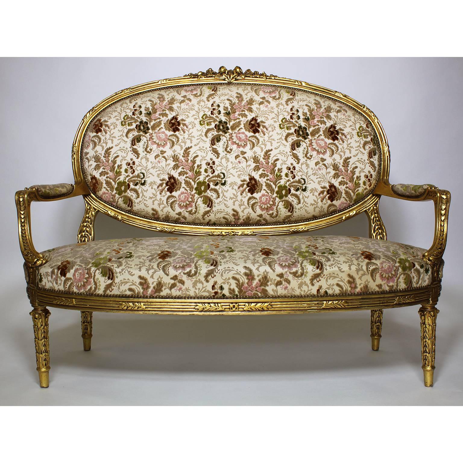 An Impressive French 19th-20th century Louis XVI style five-piece giltwood carved salon or parlor suite, comprising of a canapé (settee) and four fauteuils à la reine (Armchairs) upholstered in a colorful damask pattern burnout velvet, Paris, circa