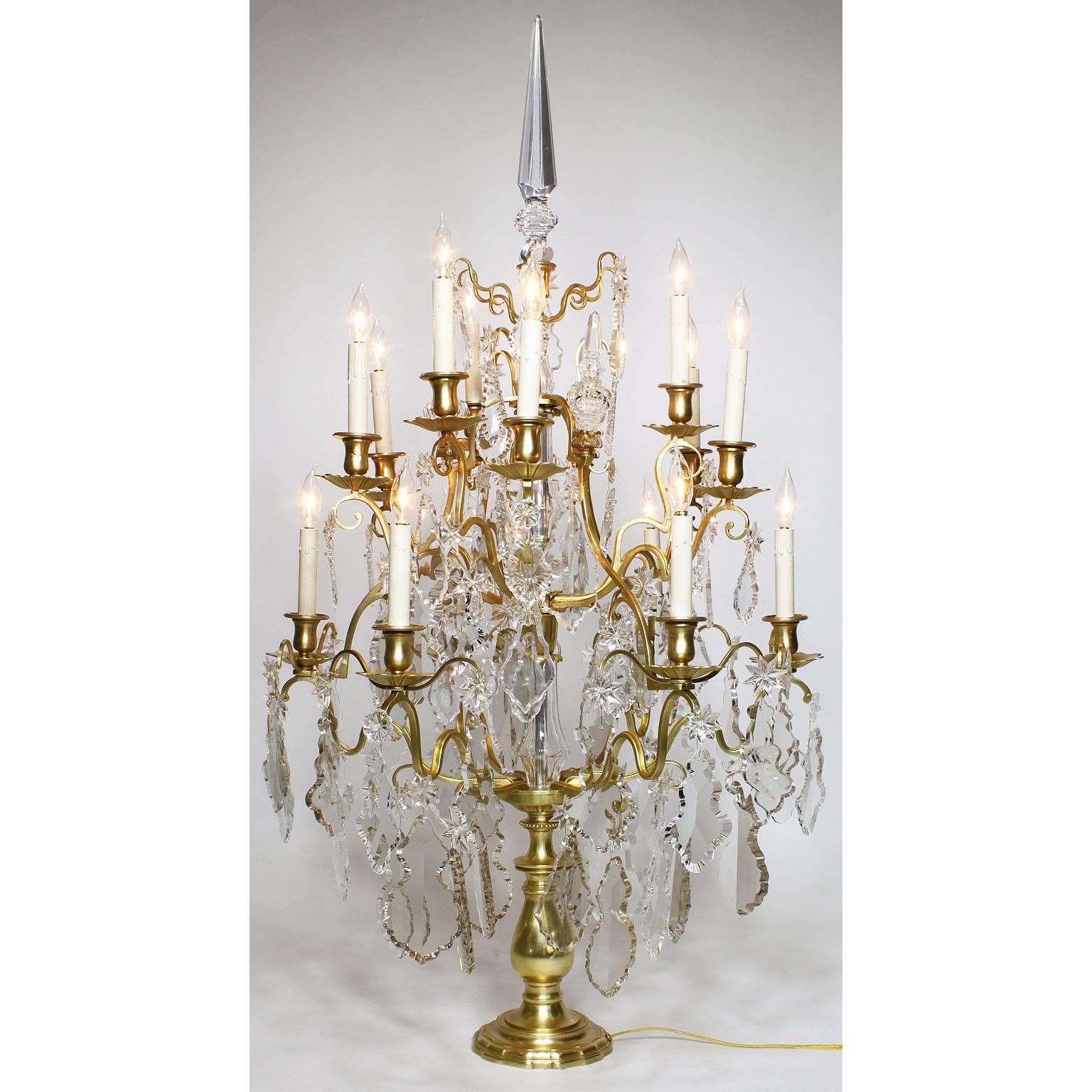 A palatial pair of French, 19th-20th century Louis XV style gilt bronze and cut-glass (some colored glass) fifteen-light girandoles table lamps. The elongated 