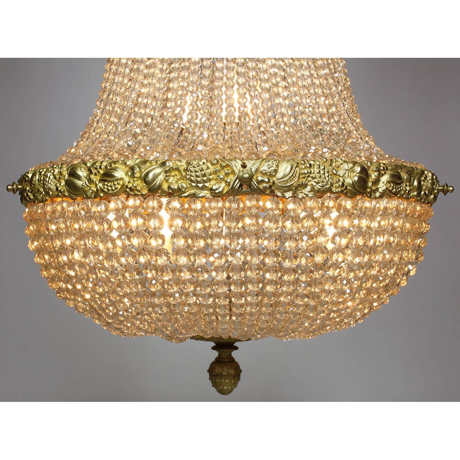 A Fine French 19th-20th Century Louis XVI Style Gilt-Bronze and Beaded Cut-Glass Basket Style Eight-Light Chandelier with a Floral and Fruits Center Rim and a Floral Canopy. Circa: Paris, 1900.

Height: 42 inches (106.7 cm)
Width: 23 1/2 inches