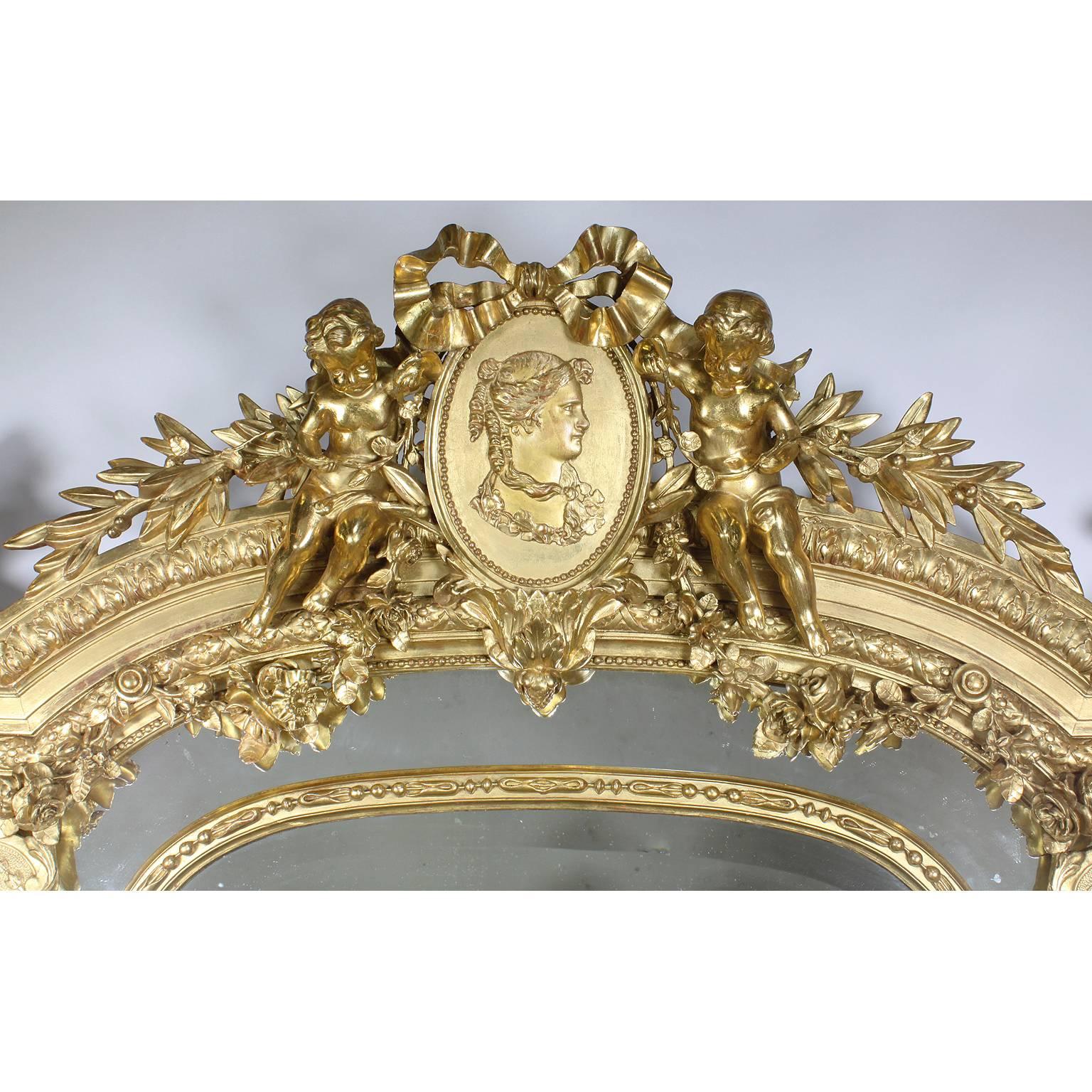 A fine and Palatial French, 19th century Louis XV style giltwood carved and Gesso figural mirror frame. The upper cresting carved with a pair of Putti holding foliate and flanking a ribbon-tied center medallion with a portrait of a Royal Maiden. The
