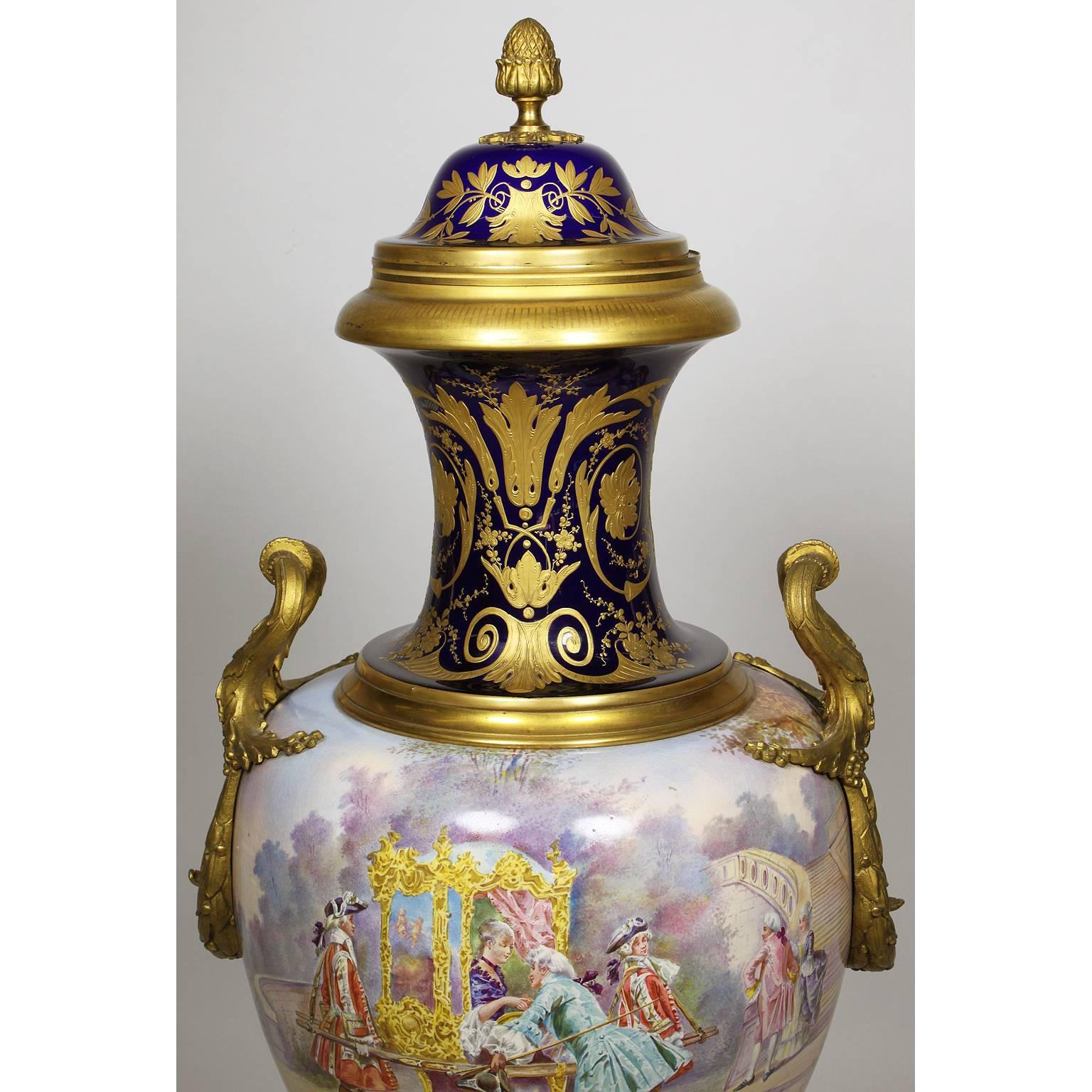 A very fine French 19th Century Napoleon III Sévres Style Porcelain and Ormolu Mounted Covered Urn, the 360 degree painted urn centered with an 18th century scene of a young Princess in palanquin with her attendants, the rear with scenes of a