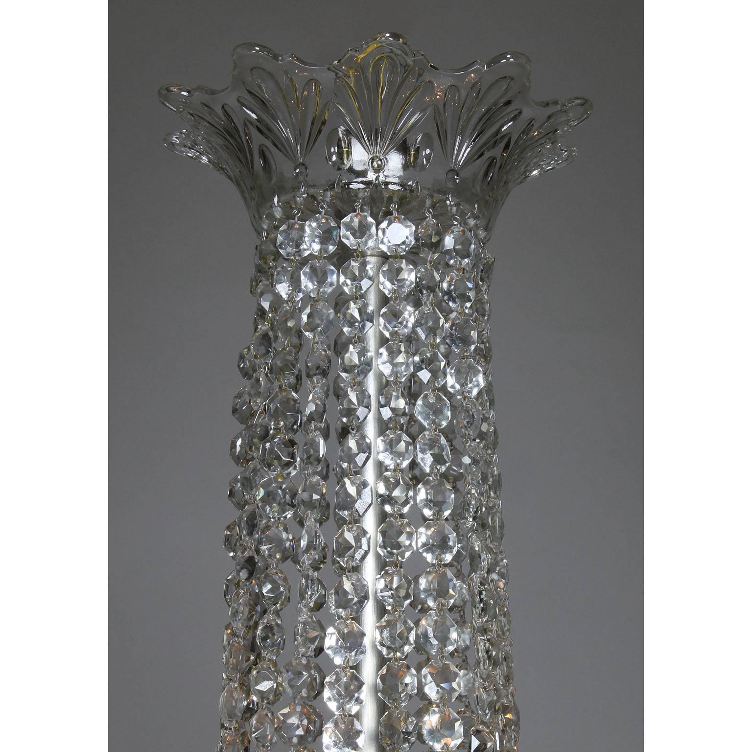 Lustre à dix lumières en bronze argenté et verre taillé (cristal) de style Louis XVI, à la manière de Baccarat. Le corps allongé est surmonté d'une rangée de prismes en verre taillé en forme de diamant, surmonté d'une rosace en verre moulé,