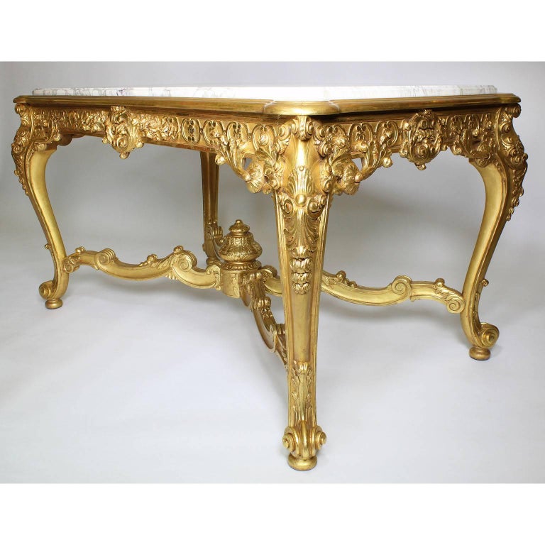 A fine French 19th-20th century Louis XV style giltwood carved center gall table with marble top. The rectangular shaped frame intricately carved frame with an 