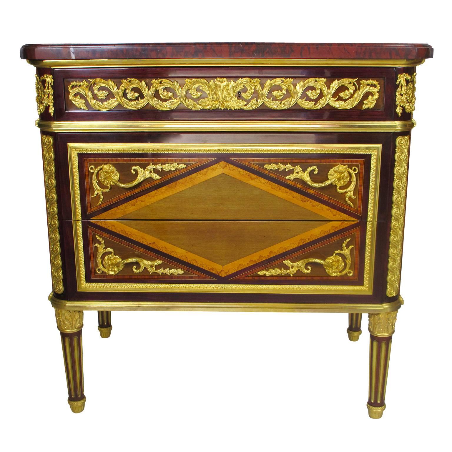 A very fine pair of French 19th century Louis XVI style Ormolu-Mounted Mahogany, Amaranth and Sycamore Marquetry Demi commodes after a model by Jean-François Leleu by Maison Picard, Paris. The rectangular Griotte Uni marble top above a scrolling