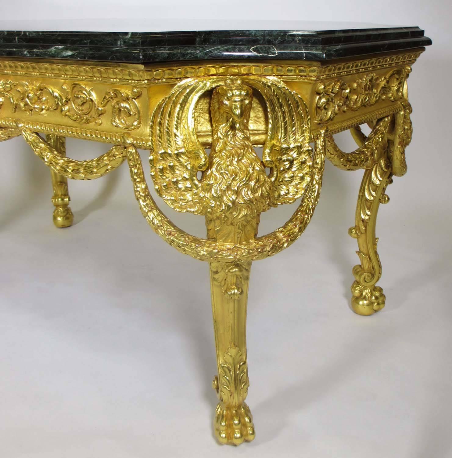 Très belle table centrale en bois doré sculpté de style Empire du XIXe siècle avec des aigles ailés et des couronnes, le médaillon central avec un taureau et un lion sur pattes au-dessus d'une sphère, avec un plateau en marbre verde d'alpes veiné