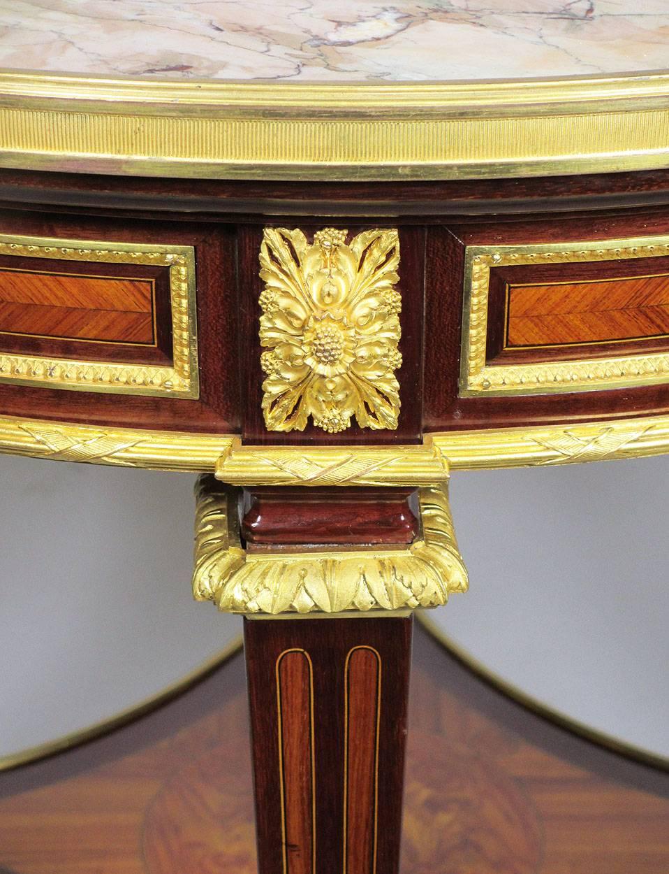 A very fine French 19th century Louis XVI style mahogany and kingwood veneer finely chased ormolu-mounted marble top gueridon side table. The circular Brêche d'Alep marble top surmounted with a gilt bronze trim raised on four square legs with a