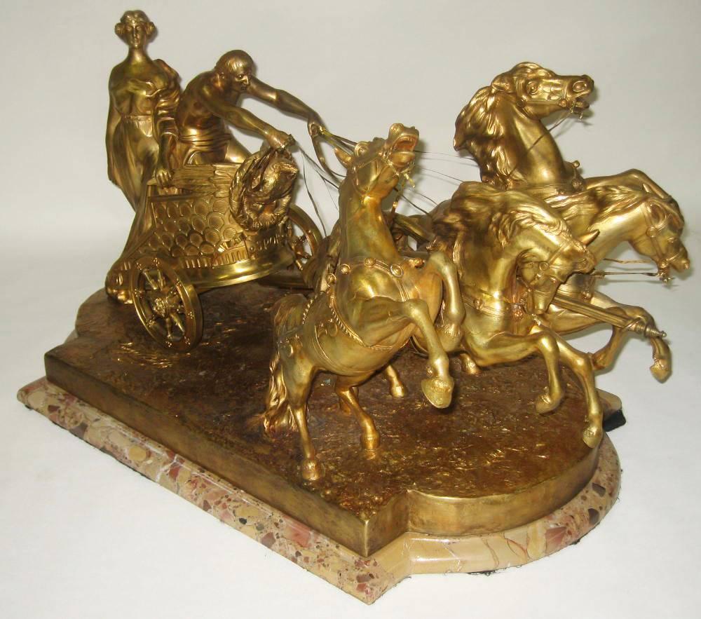 Luigi Belli (Italian, 1848-1919) a very fine and palatial Italian 19th century gilt bronze figural group depicting a 1st century Roman four-horse quadrigram racing chariot being driven by a gladiator, standing behind him, a parading goddess, all
