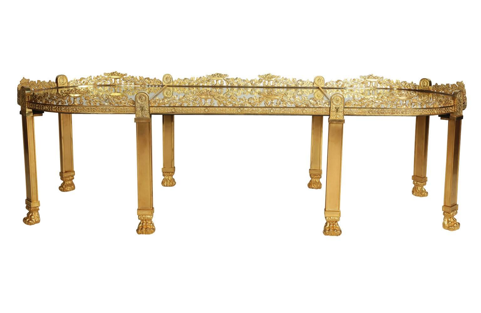 A very fine and large French Empire style Napoleon III gilt bronze Surtout-de-table, now a coffee table with later gilt bronze legs with paw-feet, with a finely chased grape and vine border and mirror plate top, in the manner of Pierre-Philippe