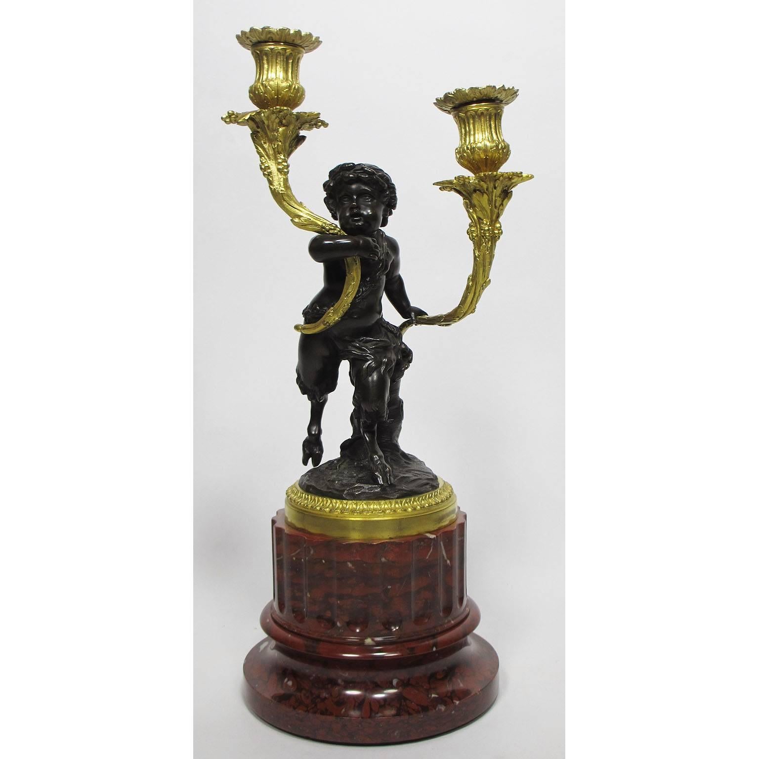A very fine pair of French 19th century Louis XVI style patinated and gilt bronze figural two-light candelabra after a model by Claude-Michel Clodion (French, 1738-1814), one modeled as a child faun, the other as a putto, each holding a gilt bronze
