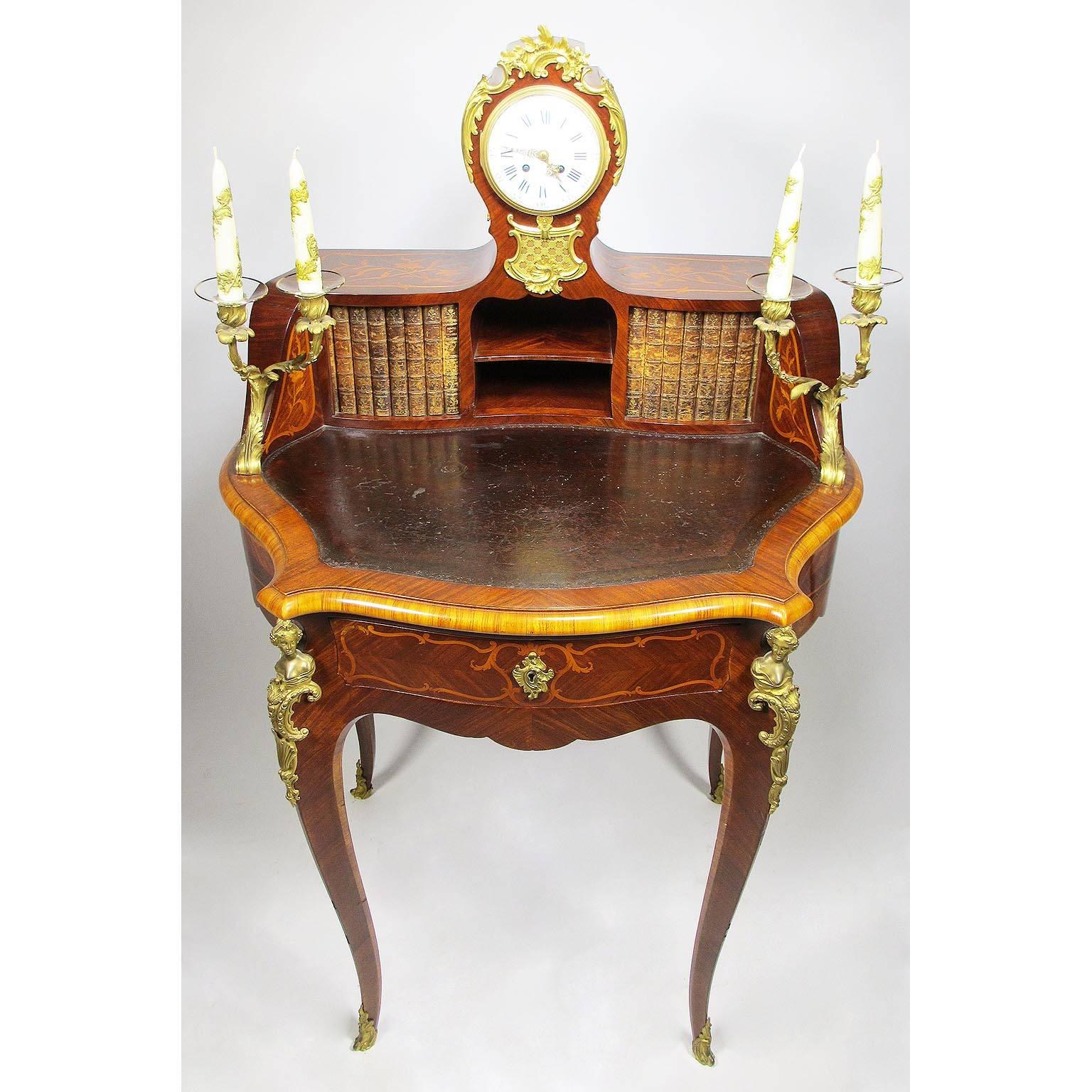 A very fine French 19th-20th century Louis XV style tulipwood and mahogany marquetry gilt bronze-mounted petit-bureau de dame (secretary). The bombe´ structure surmounted by a pair of gilt-bronze twin candelabra centered with a clock, the porcelain