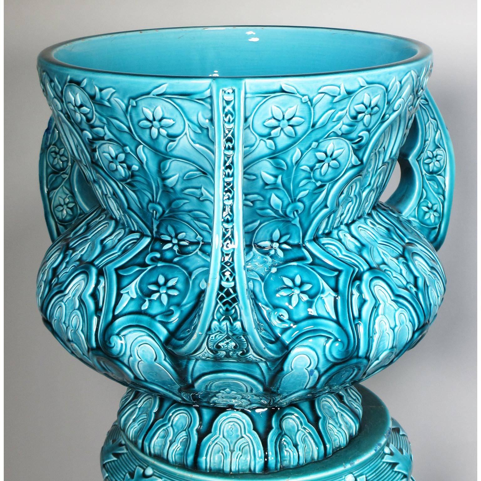 A fine pair of French 19th century Moorish style - Turquoise Glazed Pottery Jardinieres (Planters) on stands by Clément Massier (French, 1845–1917) Golfe-Juan (After 1884). The globular bowl with three upright scalloped pistol handles, molded all