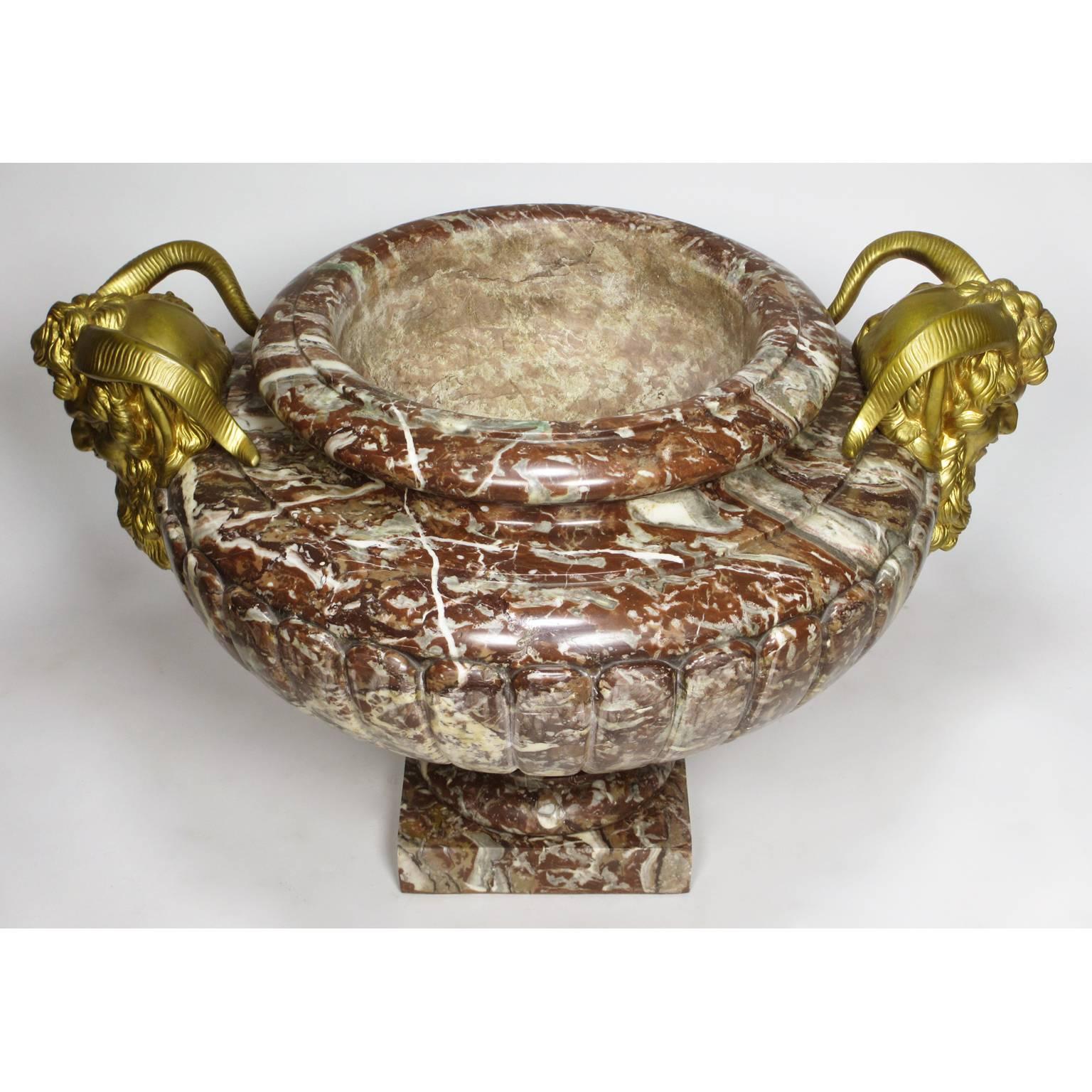A very fine and large French 19th century Louis XV style carved Rouge-Royal marble and figural gilt bronze-mounted planter-urn, surmounted with a pair of gilt bronze masks of a Satyr, Paris, circa 1880.

Height 17 1/2 inches (44.5 cm).
Width 27