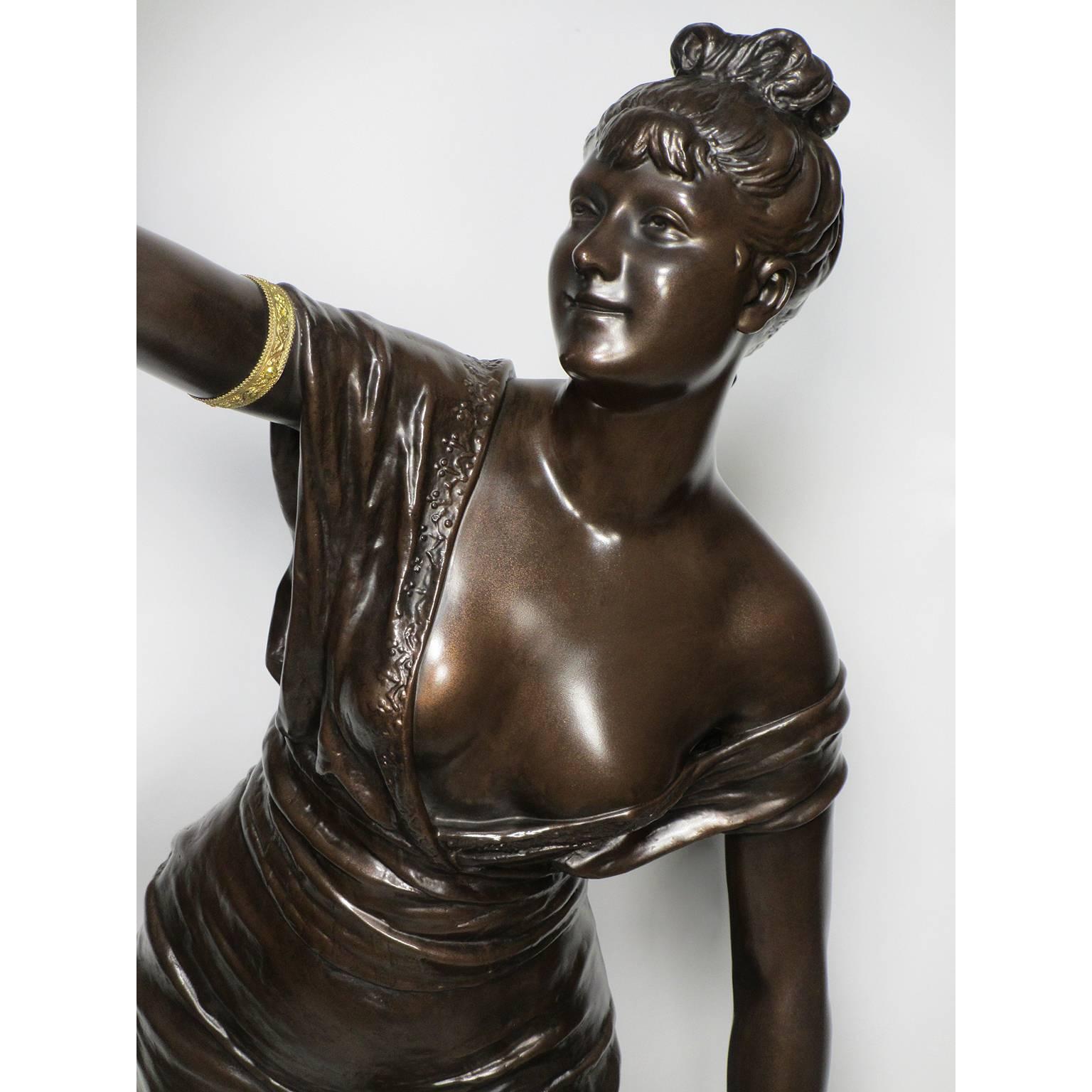 Una bella e rara figura in metallo patinato del XIX secolo di una fanciulla in piedi che regge una lanterna. L'imponente figura raffigura una giovane fanciulla vestita in modo succinto e a piedi nudi, con una tunica stretta e un'acconciatura alla