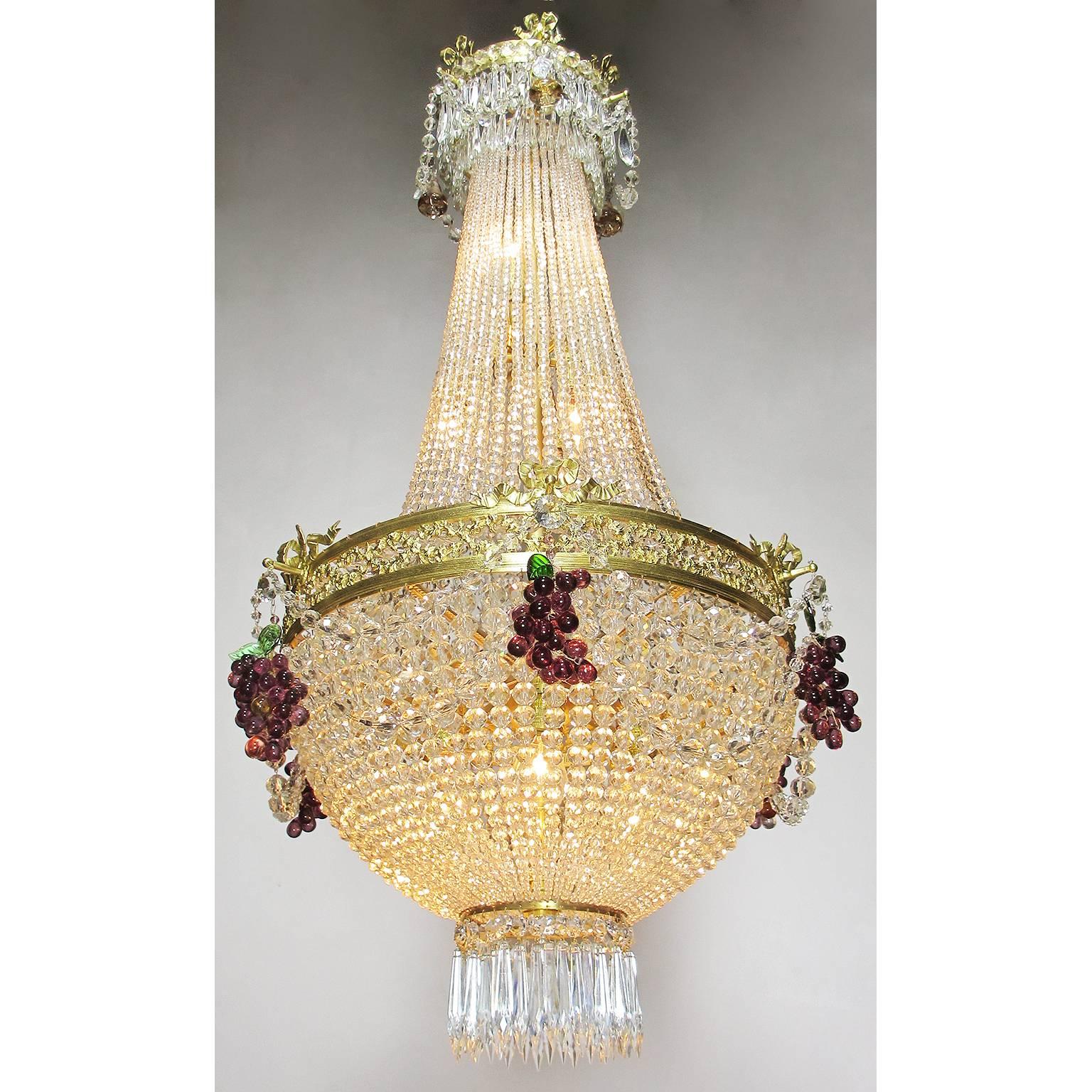 A fine French 19th-20th century Louis XVI style beaded glass and gilt-metal basket thirteen-light chandelier, the pierced gilt-metal center rim with wreaths and tied-bows, surmounted with Amethyst grape clusters and color glass leafs, the top canopy