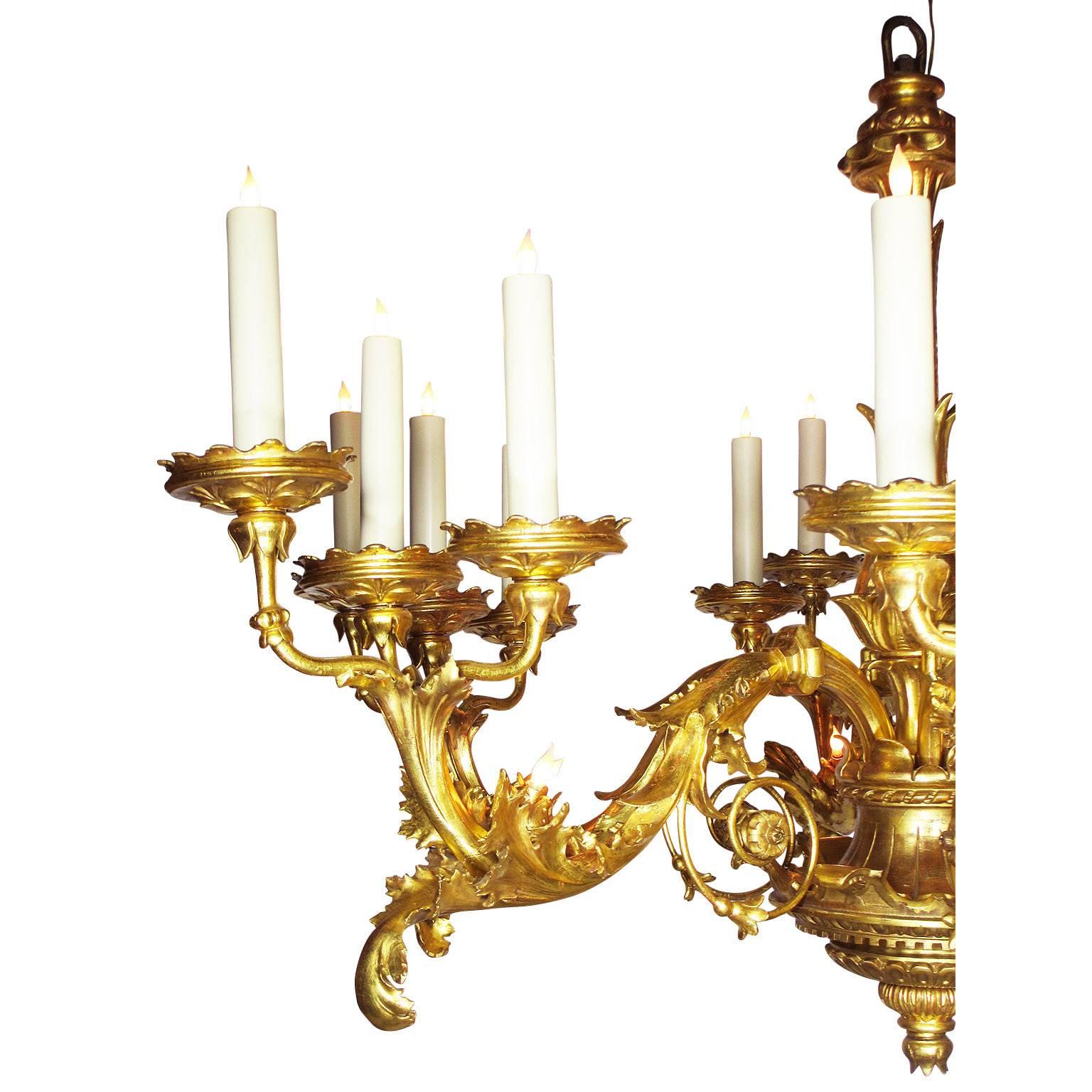 An important palatial very fine and rare Italian 19th century florentine Rococo giltwood carved six-candle arms and twenty four-light chandelier, the scrolled candle-dish supports are gilt-cast iron. The scrolled candle arms, each with three