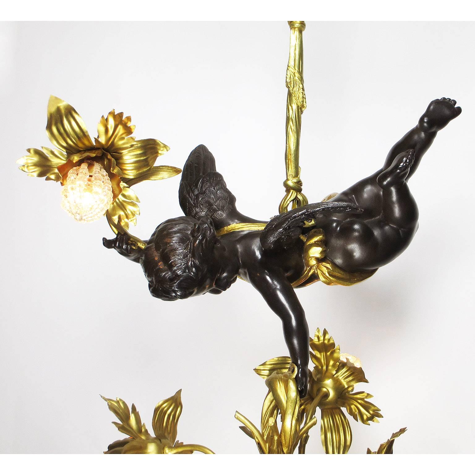 Très beau et grand lustre français de la Belle Époque en bronze patiné et doré et en métal doré à quatre lumières, représentant un chérubin en vol stationnaire tenant une composition florale en métal doré avec des lumières et des couvercles