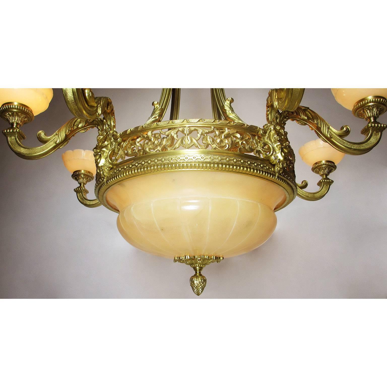 A fine and large French Art Deco gilt bronze and veined alabaster eight-light figural chandelier. The pierced floral circular frame surmounted with a large carved alabaster plafonnier supported with a bronze acorn finial, with a set of four