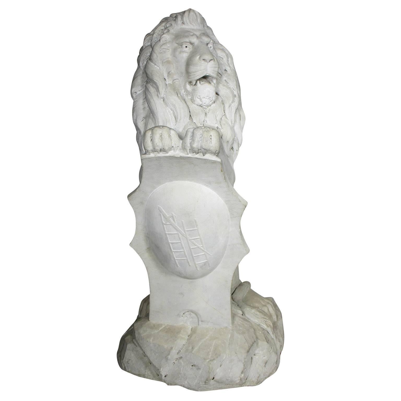 A very fine and palatial pair of English Baroque style 19th century carved marble sitting lions, the very realistic carved pair with fine attention to detail, each resting its front two paws on a coat-of-arms shield carved with the emblem of two