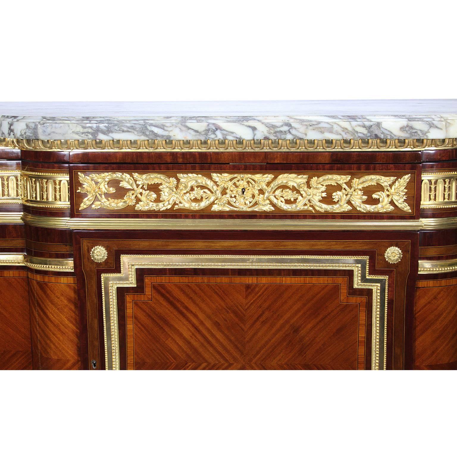 A very fine French, 19th century Louis XVI style ormolu-mounted mahogany and tulip wood commode with a brèche violette marble top, after the model by Jean-Henri Riesener (1734-1806). The mahogany body with tulip wood veneer, the frieze with three