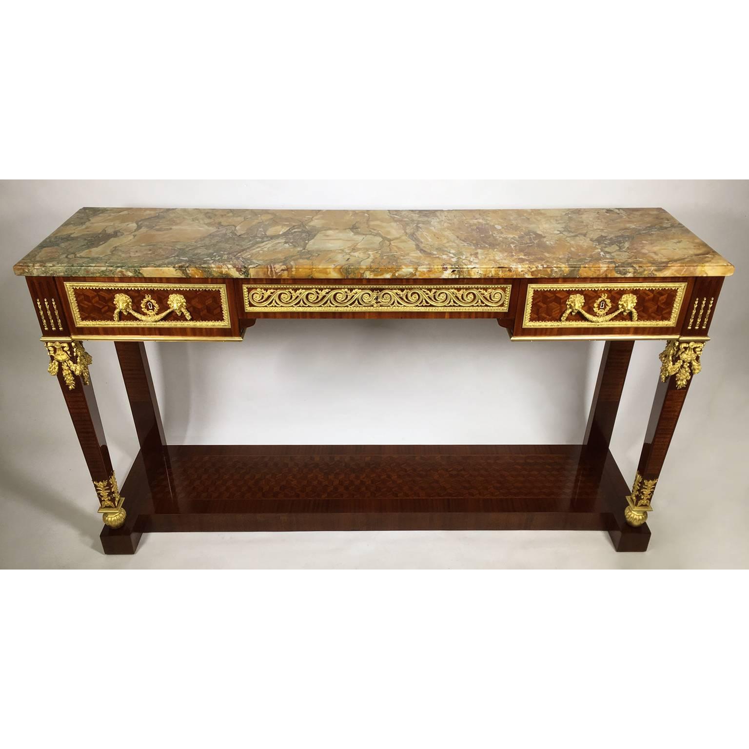 A very fine French 19th-20th century Louis XVI style mahogany and kingwood parquetry gilt bronze mounted three-drawer free-standing wall or sofa console table, after a model in the manner as Guillaume Benneman with ormolu mounts with lion-mask