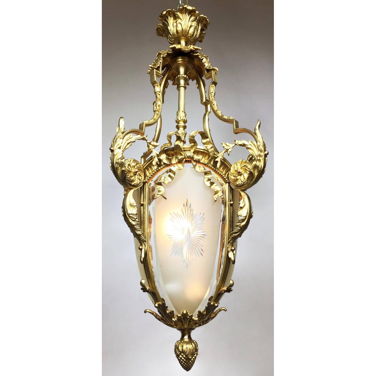 A very fine French 19th-20th century Louis XV style pear-shaped gilt bronze and diamond-cut-bent-glass lantern. The ovoid gilt bronze body with a single light, surmounted with three glass panels centered with a sunburst design. The scrolled gilt